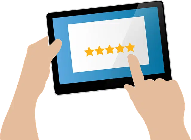 A hand tapping five stars on a tablet screen, indicating a high rating.